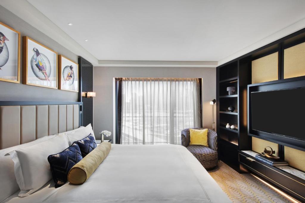 a bedroom with a large bed and a flat screen tv at The Star Grand Hotel and Residences Sydney in Sydney