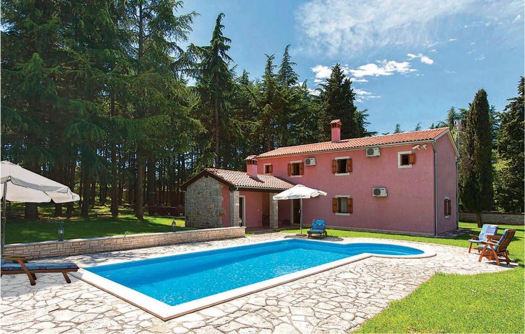 une maison avec une piscine à côté d'une maison rose dans l'établissement Stunning Home In Vrsar With Kitchen, à Vrsar
