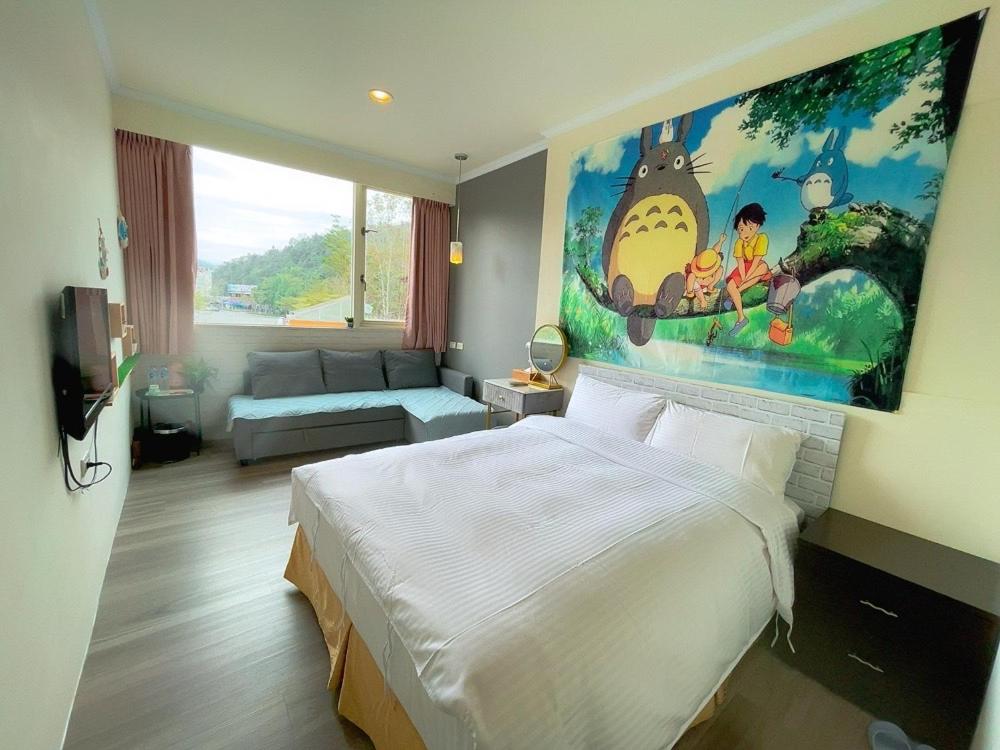 a bedroom with a bed and a large painting on the wall at Xingyue 2 Guesthouse in Yuchi