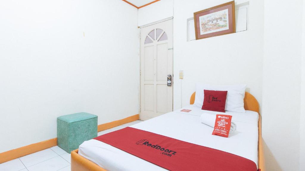 een slaapkamer met een bed met een rode deken erop bij RedDoorz @ Malibu Room BF International Las Pinas in Manilla