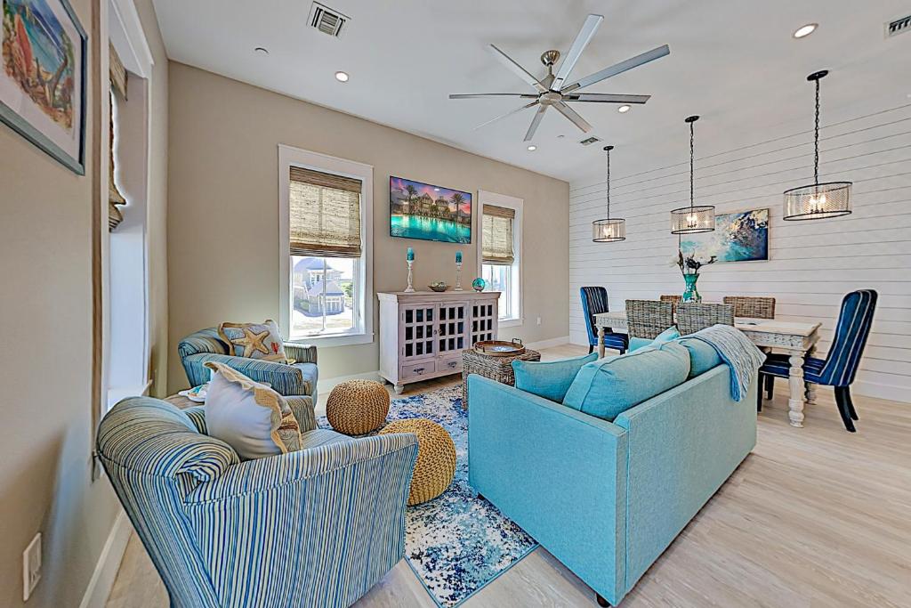 a living room with blue chairs and a dining room at Palmilla Beach Resort in Port Aransas