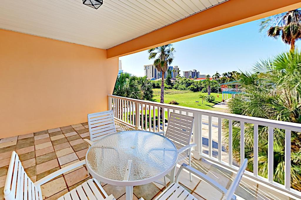 a patio with a table and chairs on a balcony at Acapulco Unit A in South Padre Island