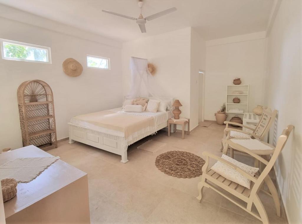 um quarto com uma cama, uma mesa e cadeiras em Golden Beach Paradise em Tangalle