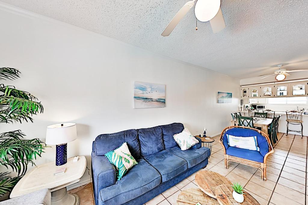 a living room with a blue couch and a table at Dolphin Condominiums #12 in South Padre Island