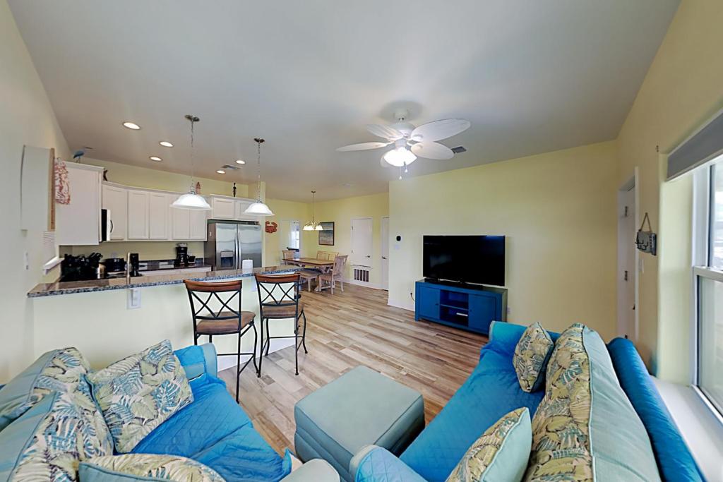 a living room with a blue couch and a kitchen at Flip Flop and Relax in Port Aransas