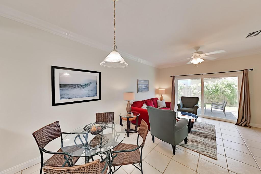 a living room with a glass table and chairs at Moon Dancer Condominiums in South Padre Island