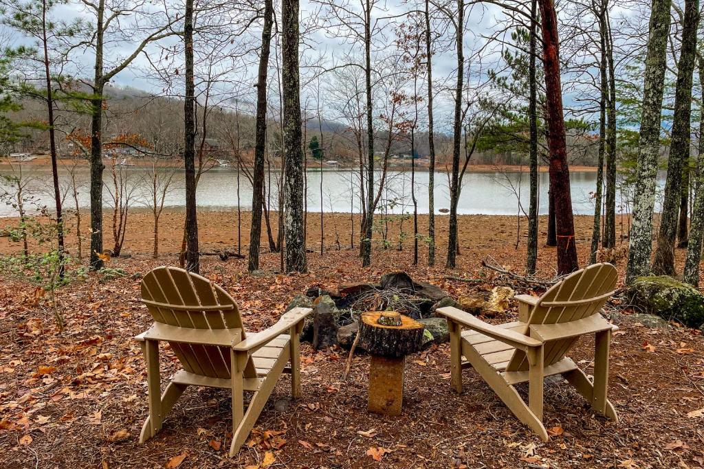 two chairs and a fire pit in the woods at Chatuge Bell in Hiawassee