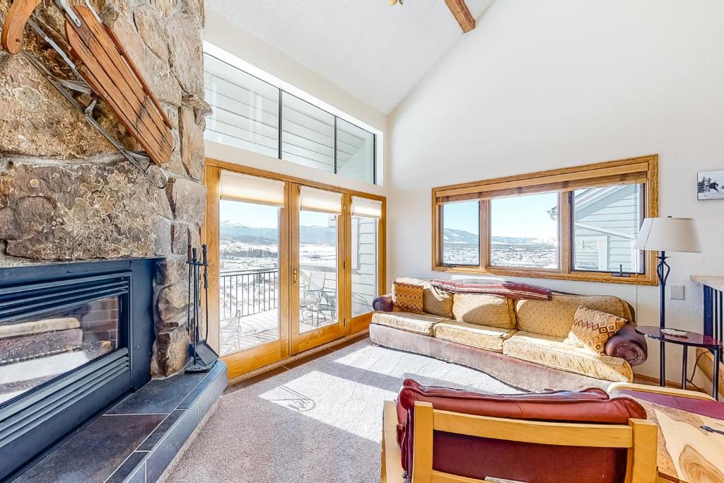 a living room with a fireplace and a stone wall at Railbender 8 in Fraser