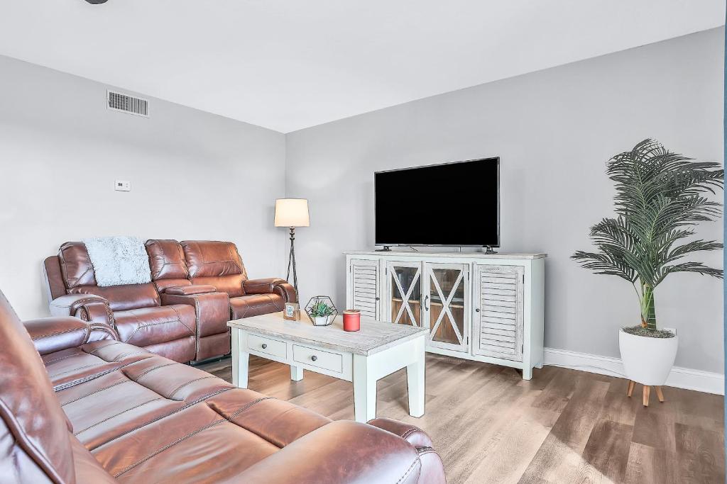 a living room with leather furniture and a flat screen tv at Ocean Breezes in Cocoa Beach