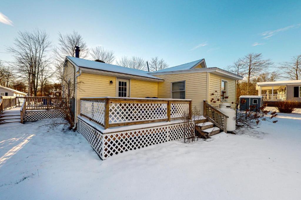 ein gelbes Haus mit einer Terrasse im Schnee in der Unterkunft To Beach Its Own in Wells