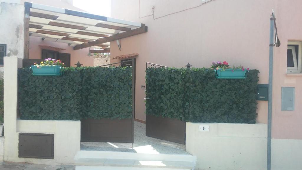 un edificio con plantas verdes y una puerta con flores en B&B Zì Micheli Salento, en Castrignano del Capo