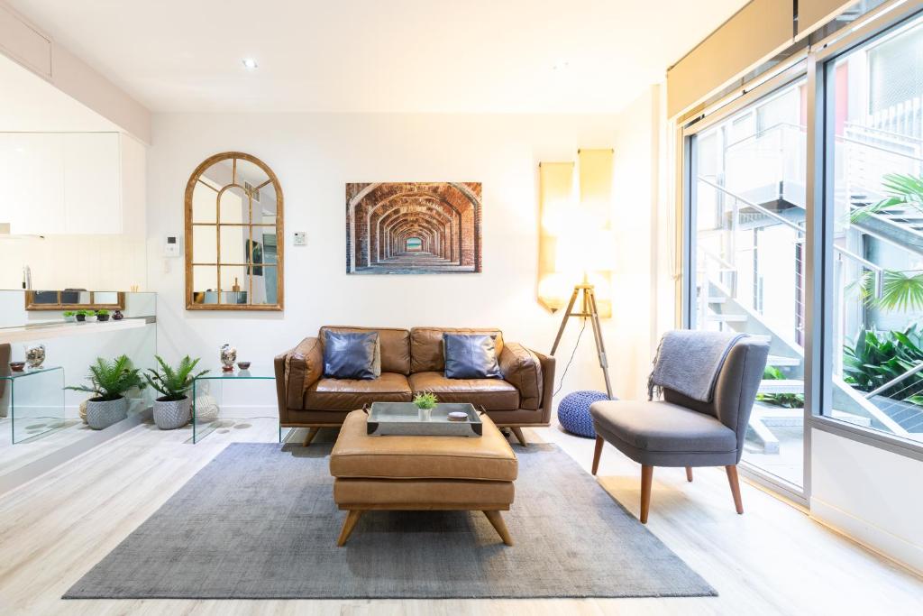 ein Wohnzimmer mit einem Sofa und einem Tisch in der Unterkunft The Port Melbourne Experience in Melbourne