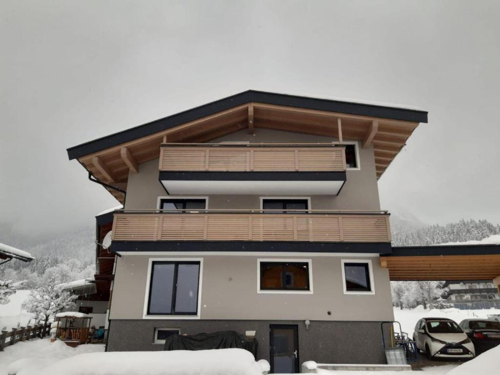 aominium building with a balcony with snow on the ground at Dani&#39;s Ferienwohnung in Söll