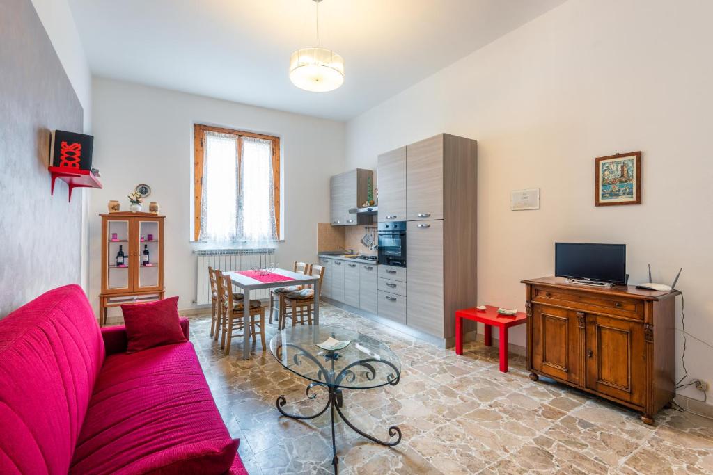 een woonkamer met een rode bank en een tafel bij Casa Vacanze Nonna Norma in San Miniato