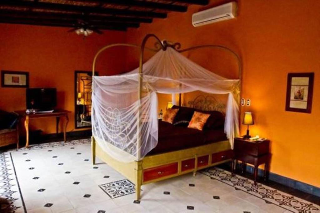 a bedroom with a canopy bed in a room at Hotel Casa Cubana Granada Nicaragua in Granada