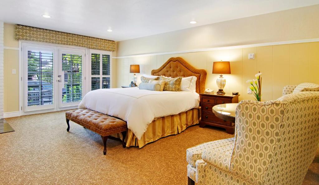 een slaapkamer met een groot bed en een stoel bij Wayside Inn in Carmel