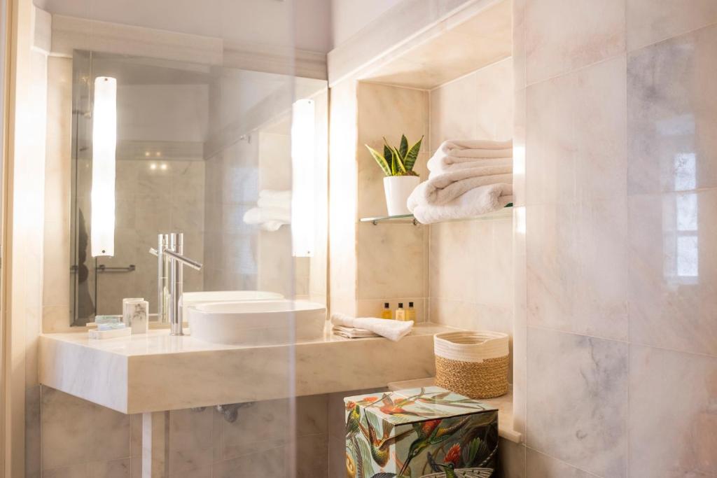 La salle de bains est pourvue d'un lavabo et d'un miroir. dans l'établissement Villa Selena, à Ermoúpoli