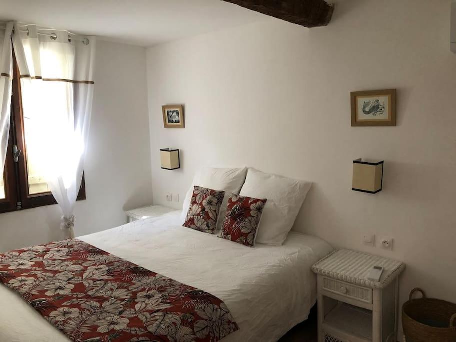 מיטה או מיטות בחדר ב-Charmante maison de village avec toit terrasse