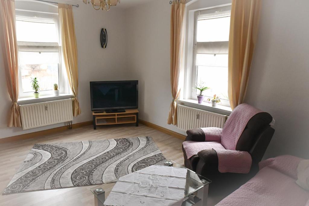 a living room with a chair and a television at Ferienwohnung, Messenah, ruhige Stadtlage Löbau in Löbau