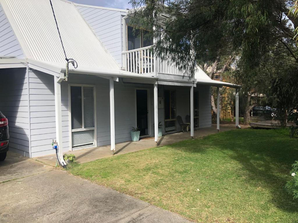 uma casa branca com um alpendre e um quintal em Dunsborough Beach Shack em Dunsborough