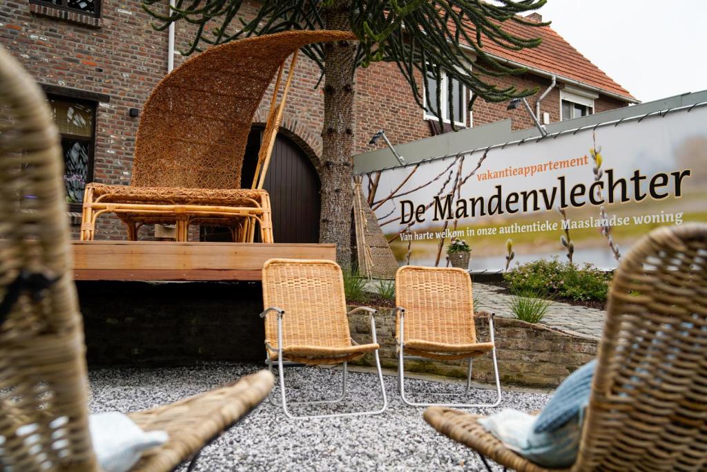 een groep stoelen en een bank op een binnenplaats bij De Mandenvlechter in Dilsen-Stokkem