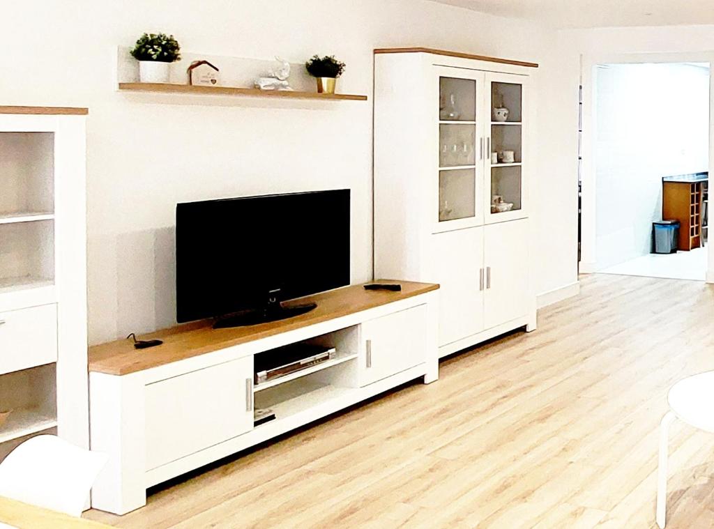 um centro de entretenimento branco com uma televisão numa sala de estar em Apto Ramón y Cajal,1- Céntrico y cerca de Playa San Lorenzo-3hab garaje opc em Gijón