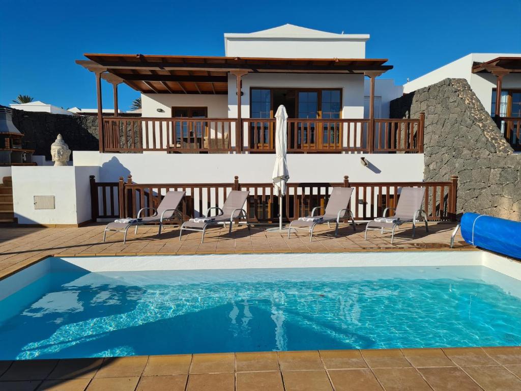 una villa con piscina e una casa di Luxury 4-Bedroom Villa With Heated Pool + Sea View a Playa Blanca