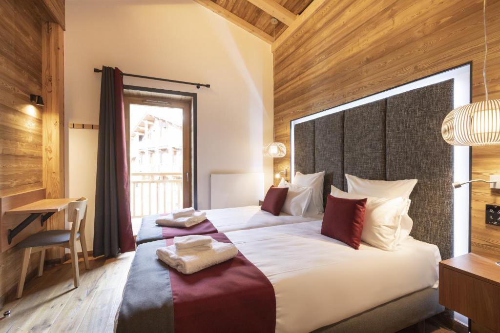 a bedroom with a large bed and a desk at Les Balcons Platinium Val Cenis in Lanslevillard