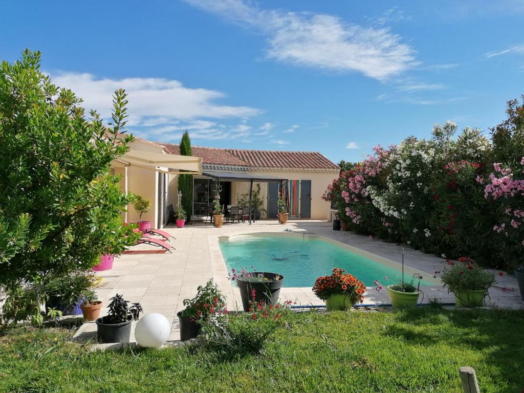 a house with a swimming pool in a yard at JULIANA in Eyragues