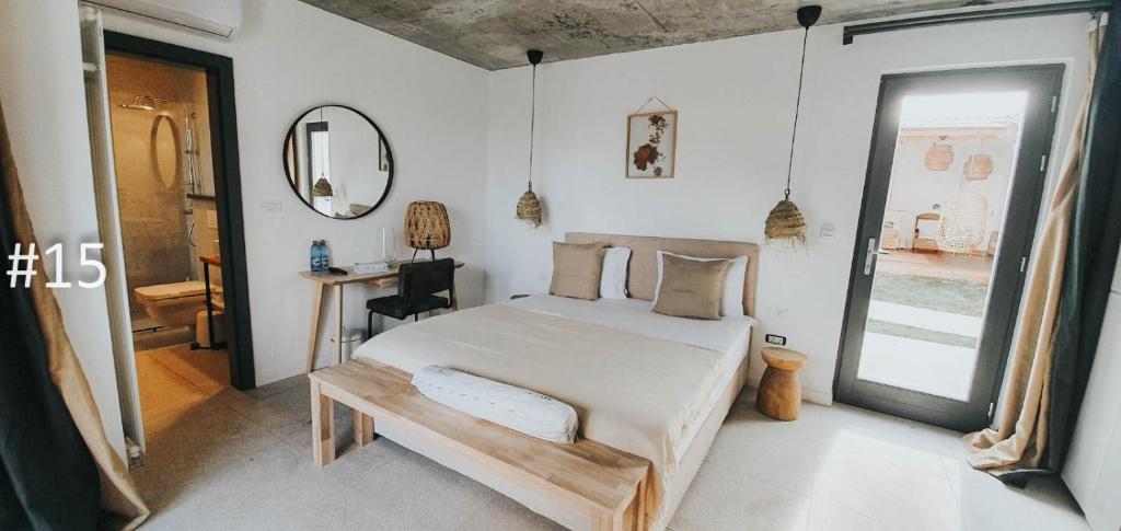 a bedroom with a bed and a table and a mirror at The Pines - Experiment Favelas in Vama Veche