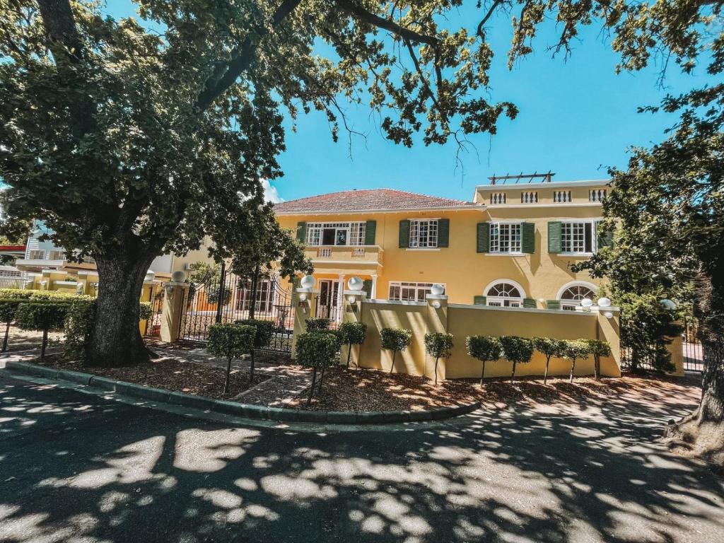 a yellow house with a fence in front of it at De Haas Luxury Living at Villa Grande in Stellenbosch