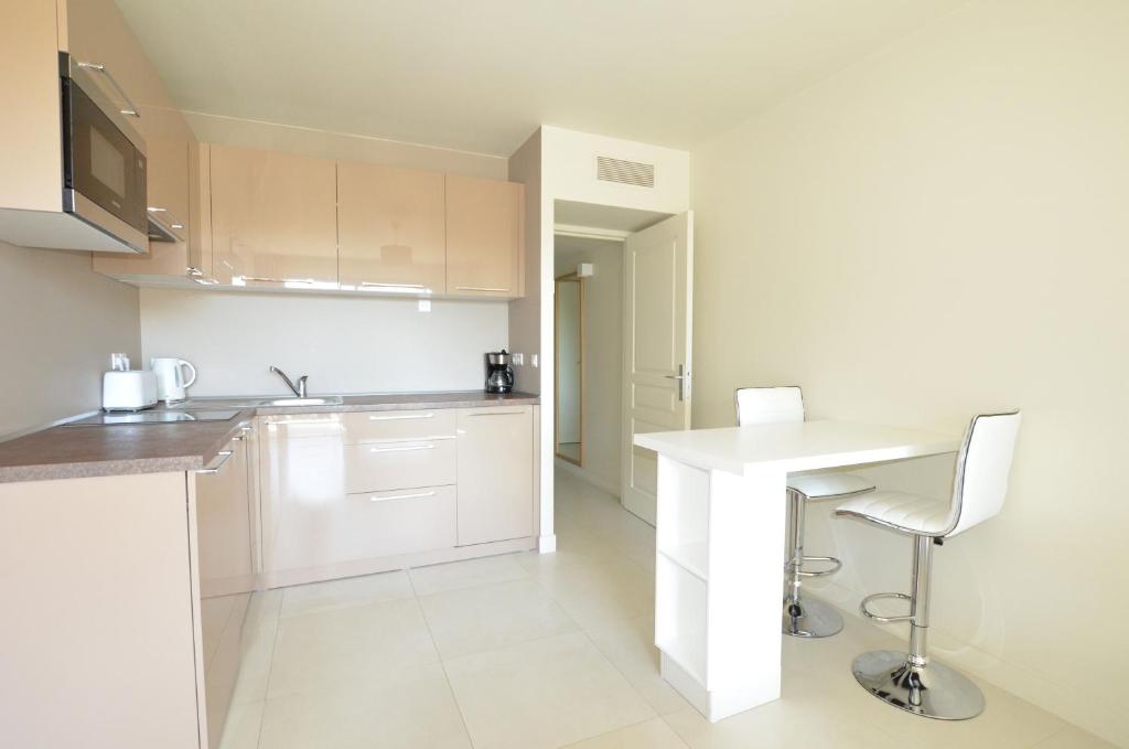 a kitchen with white cabinets and a white counter top at La Perle d'Eze - Aparthotel in Éze
