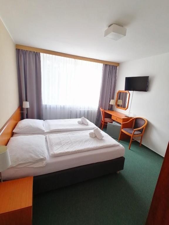 Postel nebo postele na pokoji v ubytování Horský hotel Jelenovská s bazénem v ceně