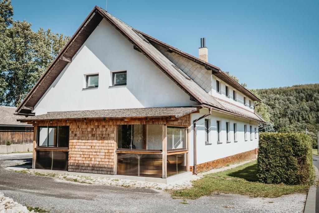 une maison blanche avec un toit marron dans l'établissement U Ztraceného potoka, à Vápenná