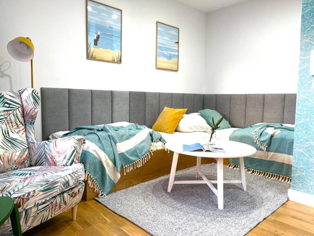 a living room with a couch and a table at Apartament 3Fale - Bulwar Portowy, 3 min do plaży i promenady in Ustka