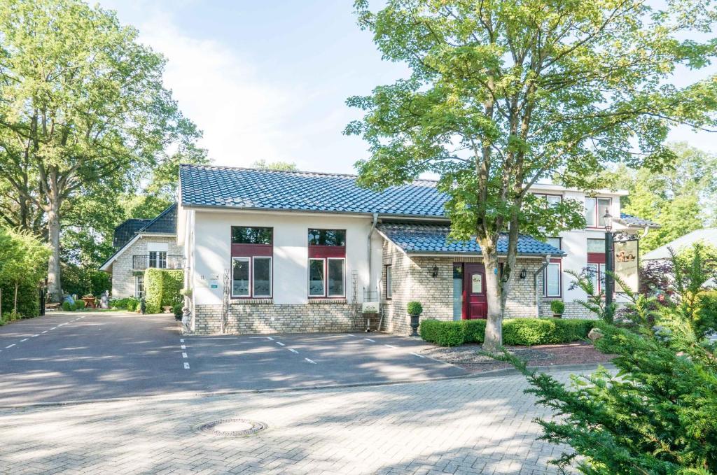 une maison blanche avec un toit bleu dans l'établissement Hotel Groote Engel, à Emlichheim