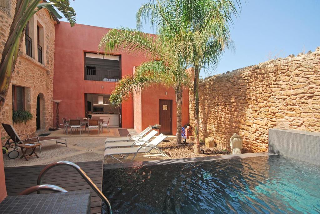 アルクーディアにあるVilla Murallasのレンガの壁に隣接するスイミングプール付きの家