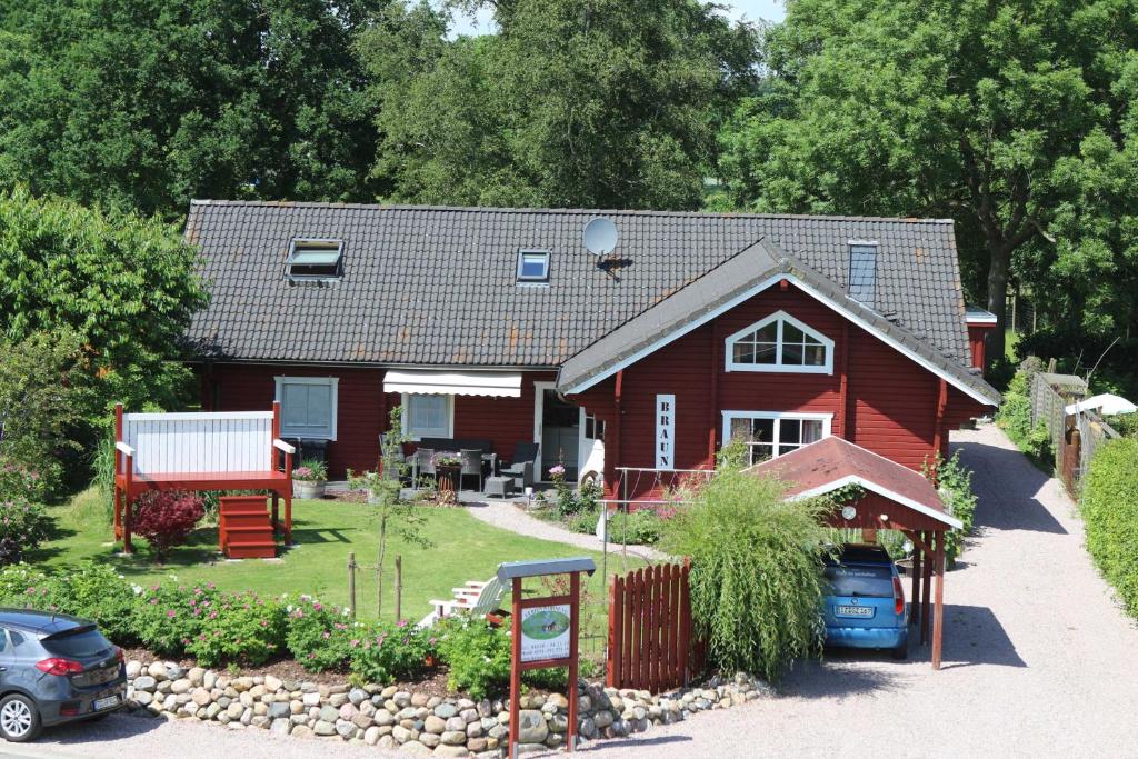 ein rotes Haus mit einem davor geparkt in der Unterkunft Holthus in Kollmar
