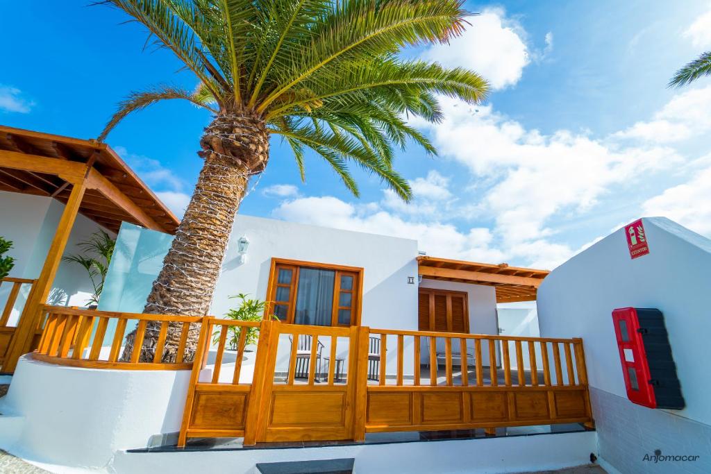 a palm tree in front of a house at Luxury Villas Anjomacar in Teguise