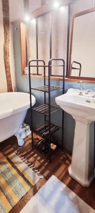 a bathroom with a sink and a tub next to a sink at La Dragonne, petite maison au centre de Bellême, jardin, cuisine équipée, vue forêt in Bellême