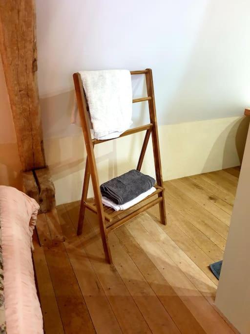 a wooden chair sitting on a wooden floor in a room at La Dragonne, petite maison au centre de Bellême, jardin, cuisine équipée, vue forêt in Bellême