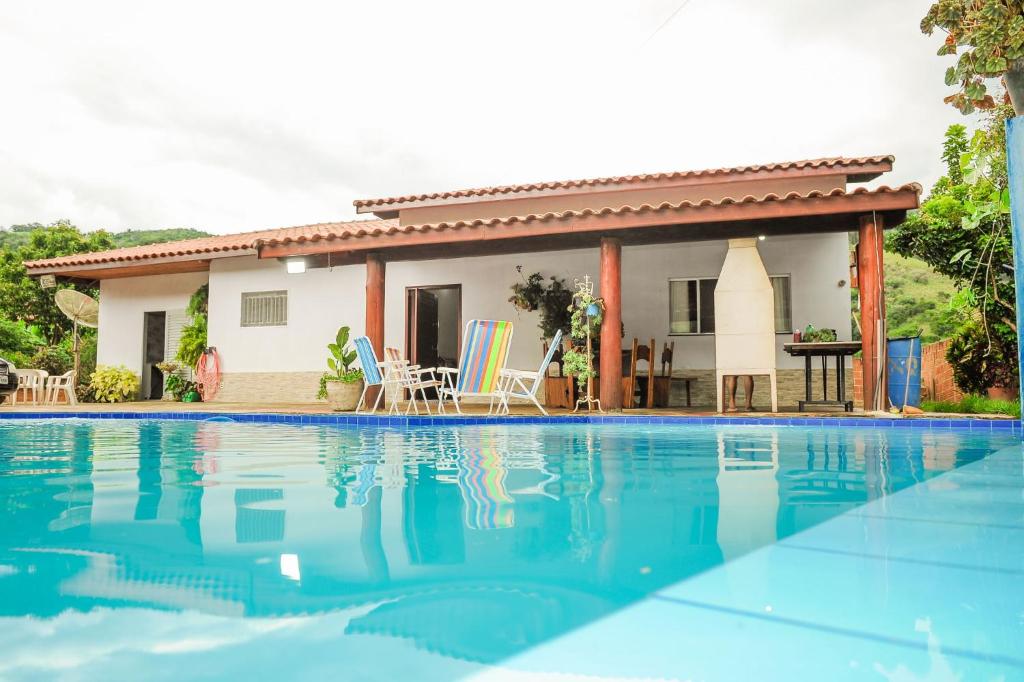 une maison avec une piscine en face de celle-ci dans l'établissement Chácara dos Teixeira, à Socorro