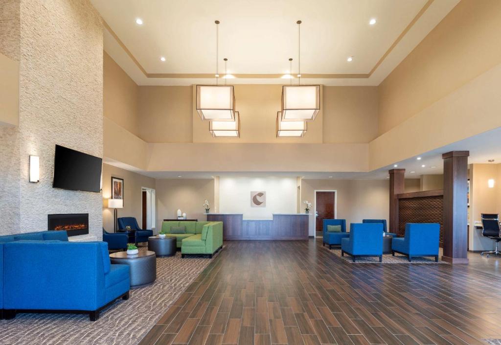 a lobby with blue chairs and a fireplace at Comfort Suites in Summerville