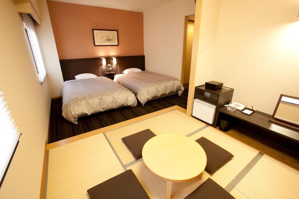 Postel nebo postele na pokoji v ubytování Toyama Manten Hotel