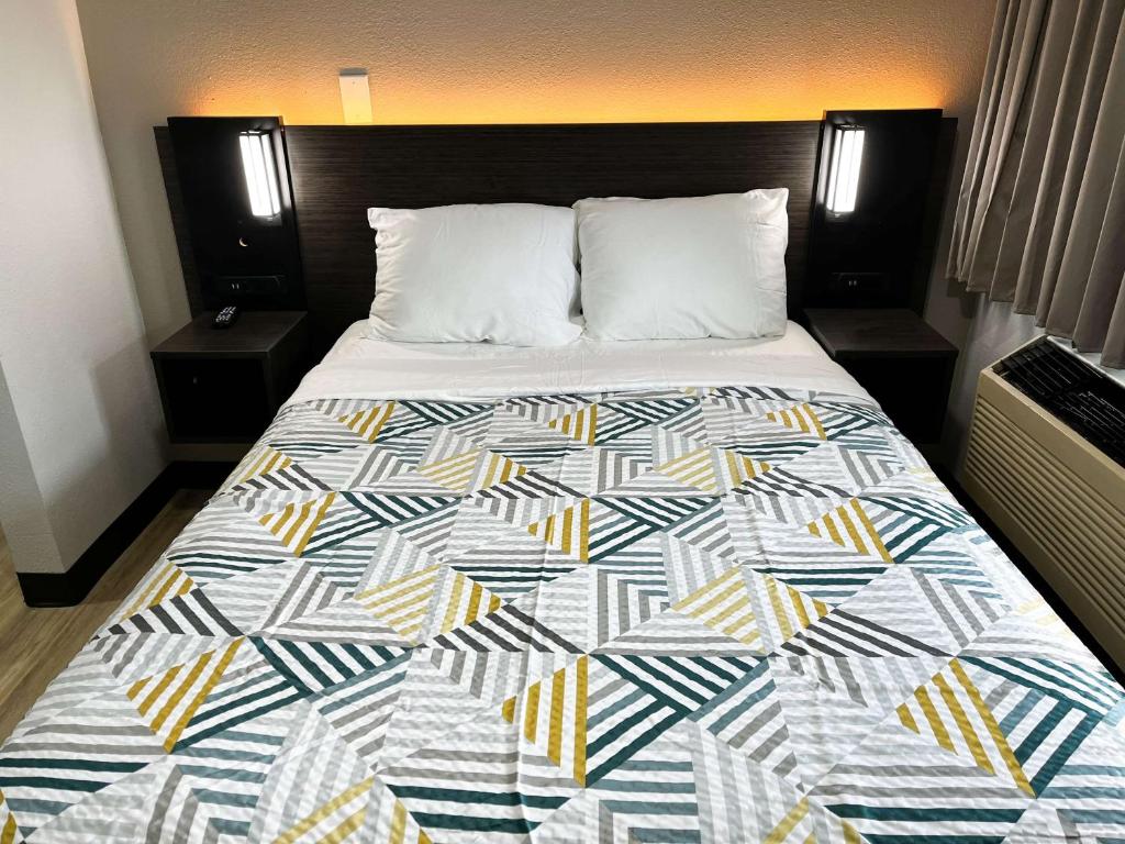 a bed in a hotel room with a quilt on it at Studio 6 Lafayette, LA I-10 & I-49 N in Lafayette