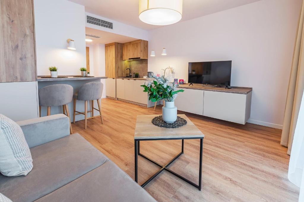 VacationClub – Jantaris Apartament A 35 في ميلنو: غرفة معيشة مع أريكة وطاولة
