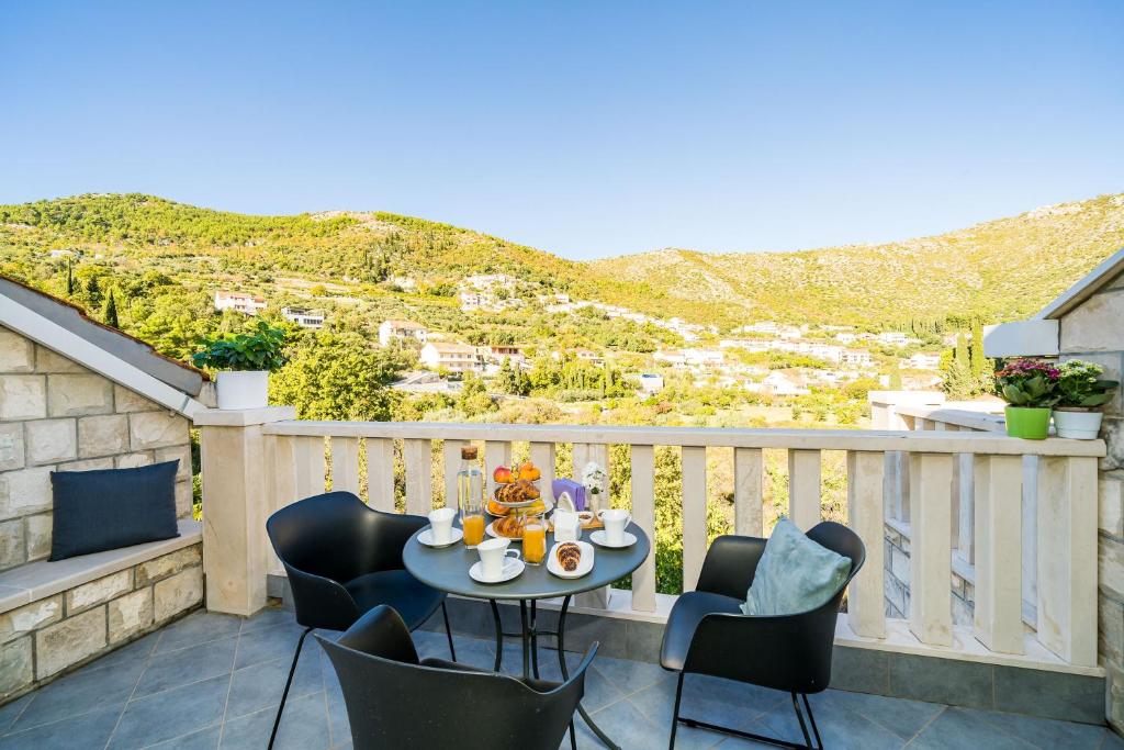 patio con mesa y sillas en el balcón en Apartments Vodnica en Zaton