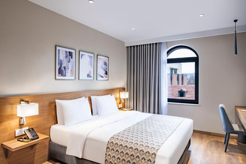 Postel nebo postele na pokoji v ubytování Clocks Hotel Tbilisi