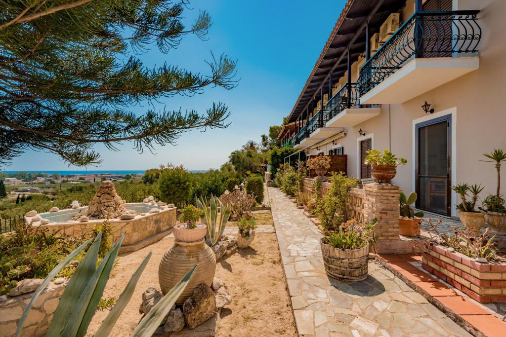 a house with a garden with potted plants at Notos Studios in Laganas