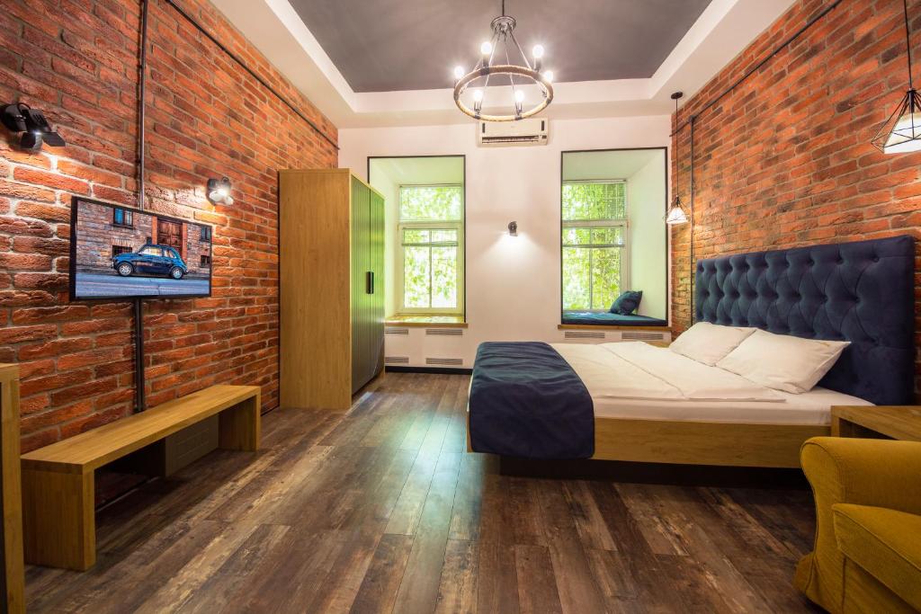 a bedroom with a bed and a brick wall at Loft Apartments near Landscape Alley in Kyiv
